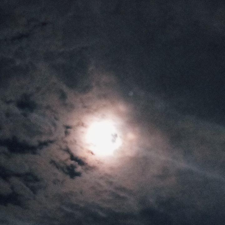 Night sky with partially visible moon and clouds.