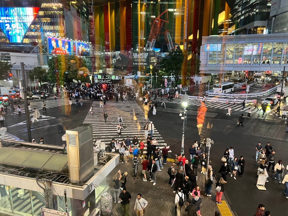 Intersection animée de la ville avec des piétons et des éclairages urbains.