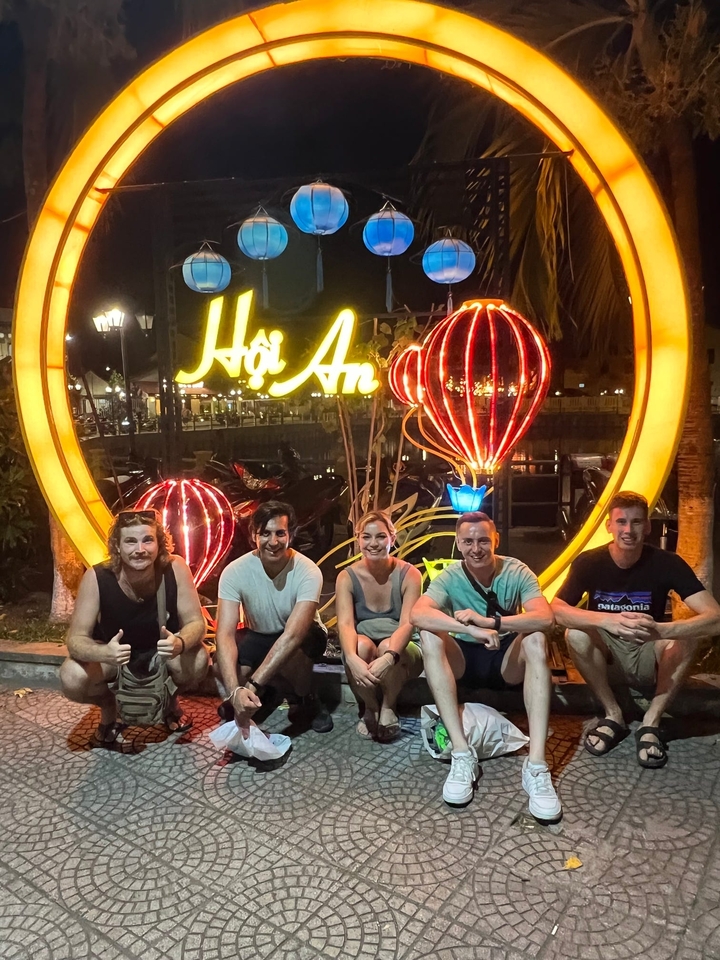 A group of people posing in front of the Hoi An lanterns at night.