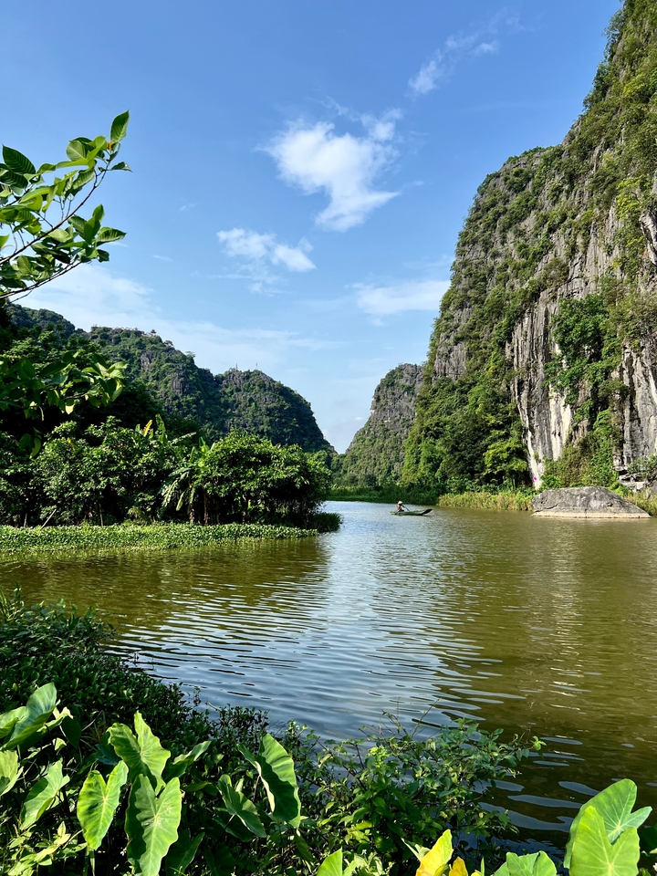 Scenic river winding through lush limestone mountains.