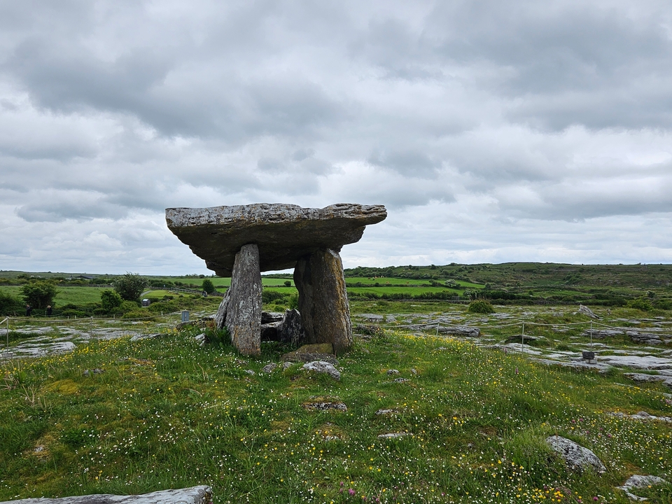 Ancient stone structure in a grassy field.