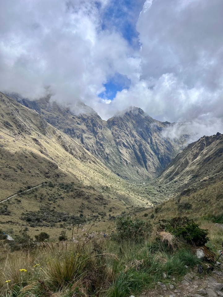 Dramatic mountain valley with cloudy sky.