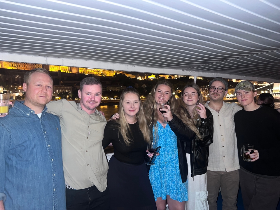 Group enjoying a night cruise with city lights in the background.