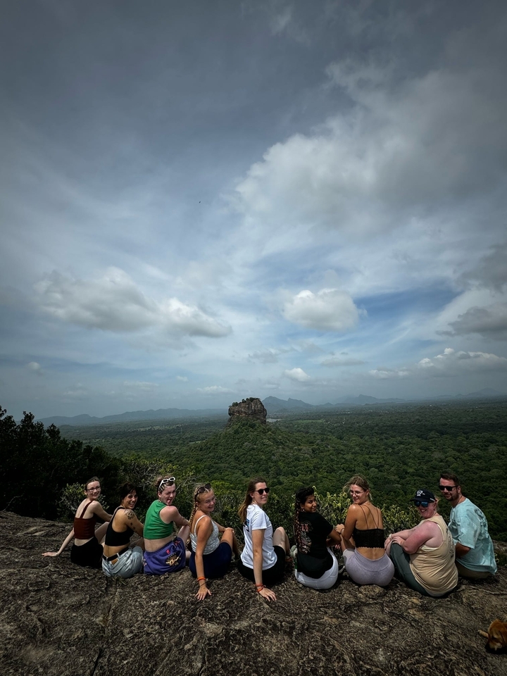 Large rock formation in a vast green landscape.