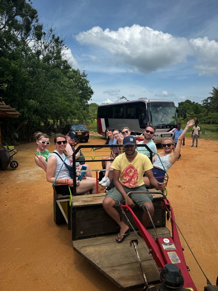 Group in a cart pulled by a tractor.