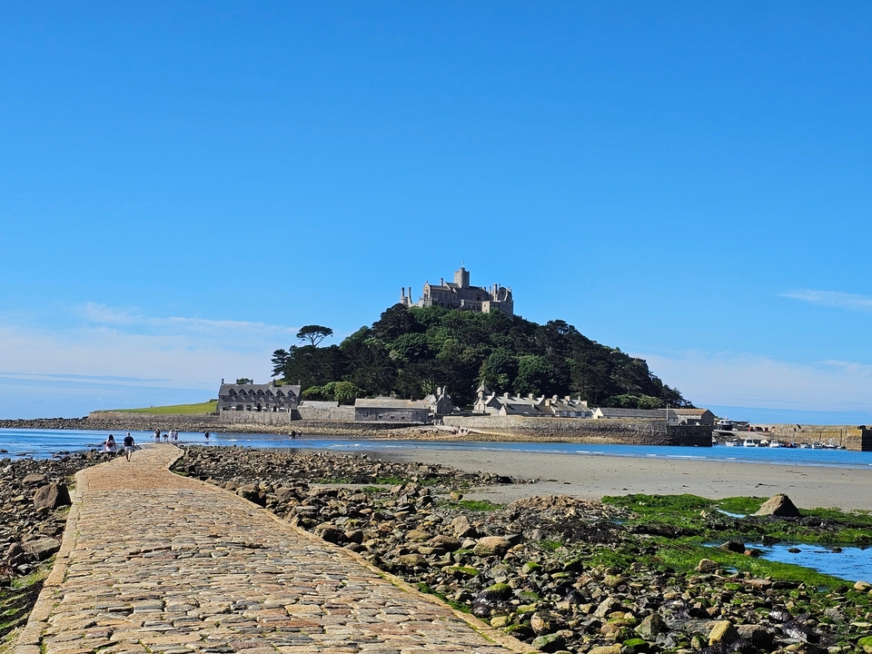 Saint Michael's Mount with a castle on a hill surrounded by water.