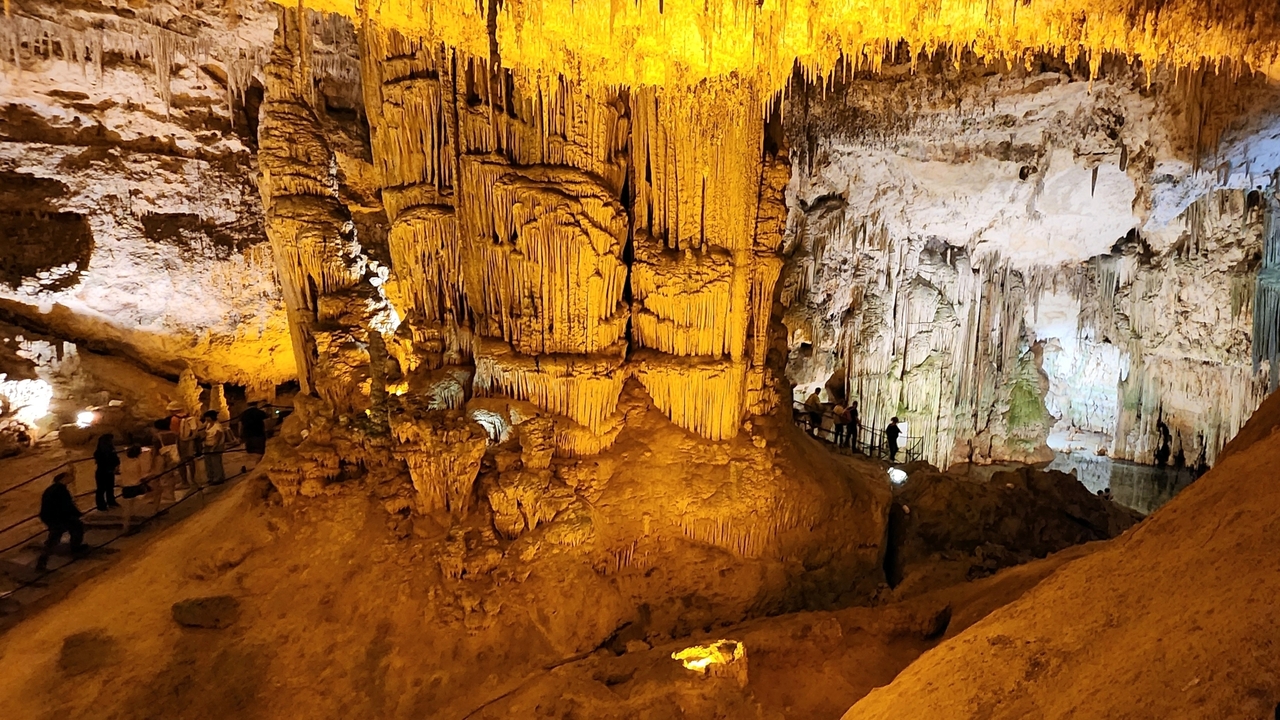 Illuminated cave interior with stalactites.