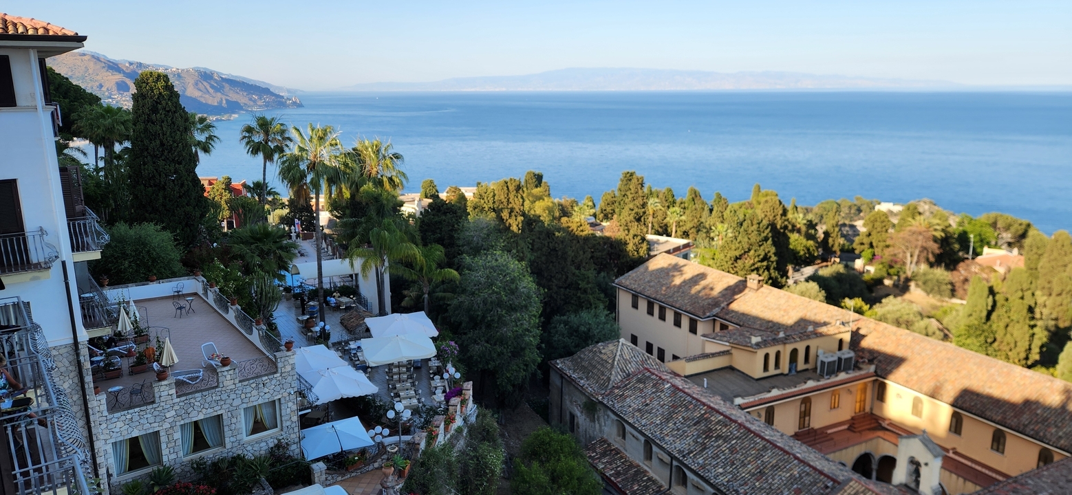 View from a terrace overlooking a coastal landscape.