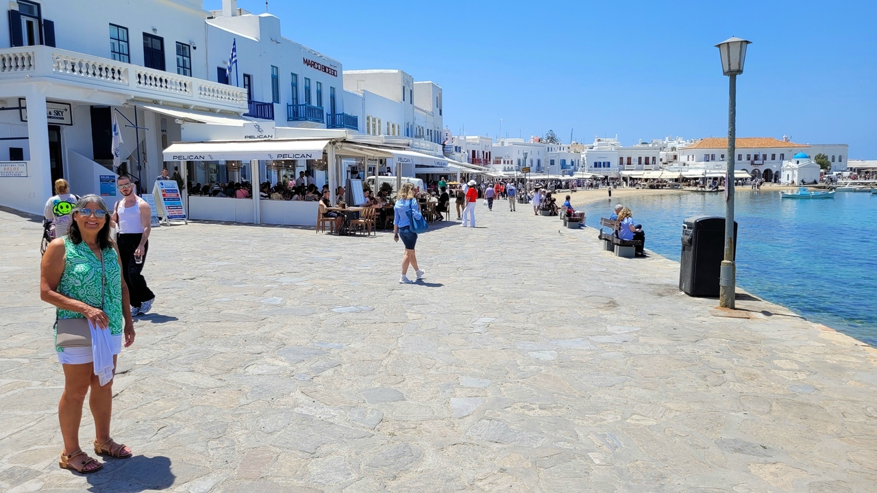 Seaside walkway with people and restaurants.