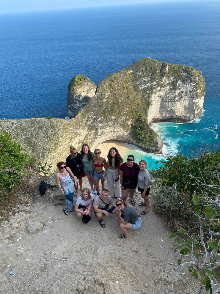 Group posing in front of a beach cliffside view.