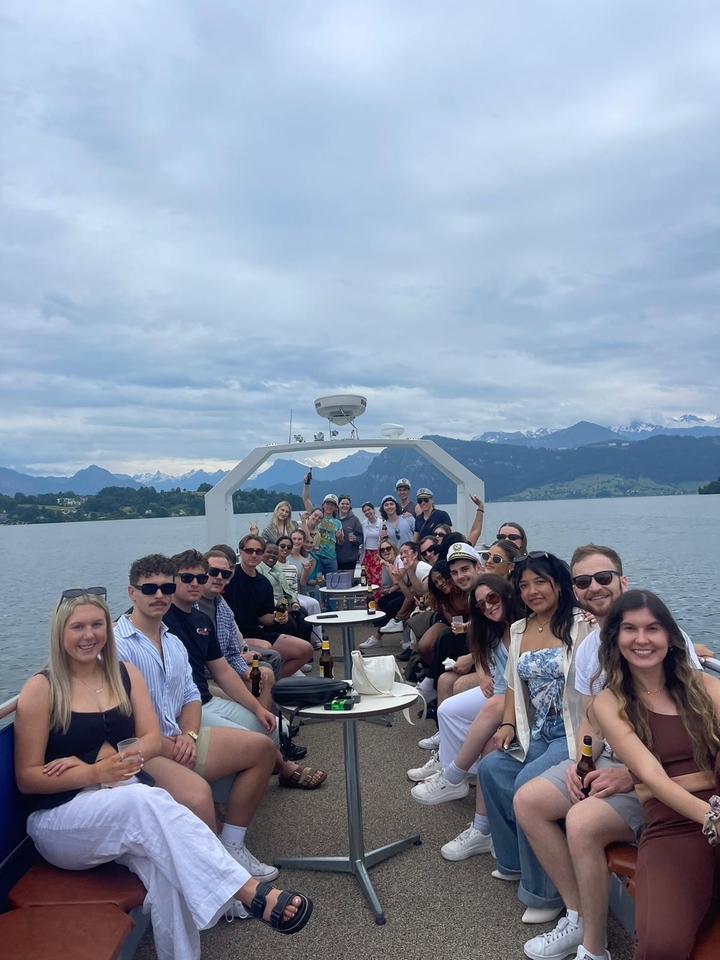 Group enjoying boat ride with mountains in the background.