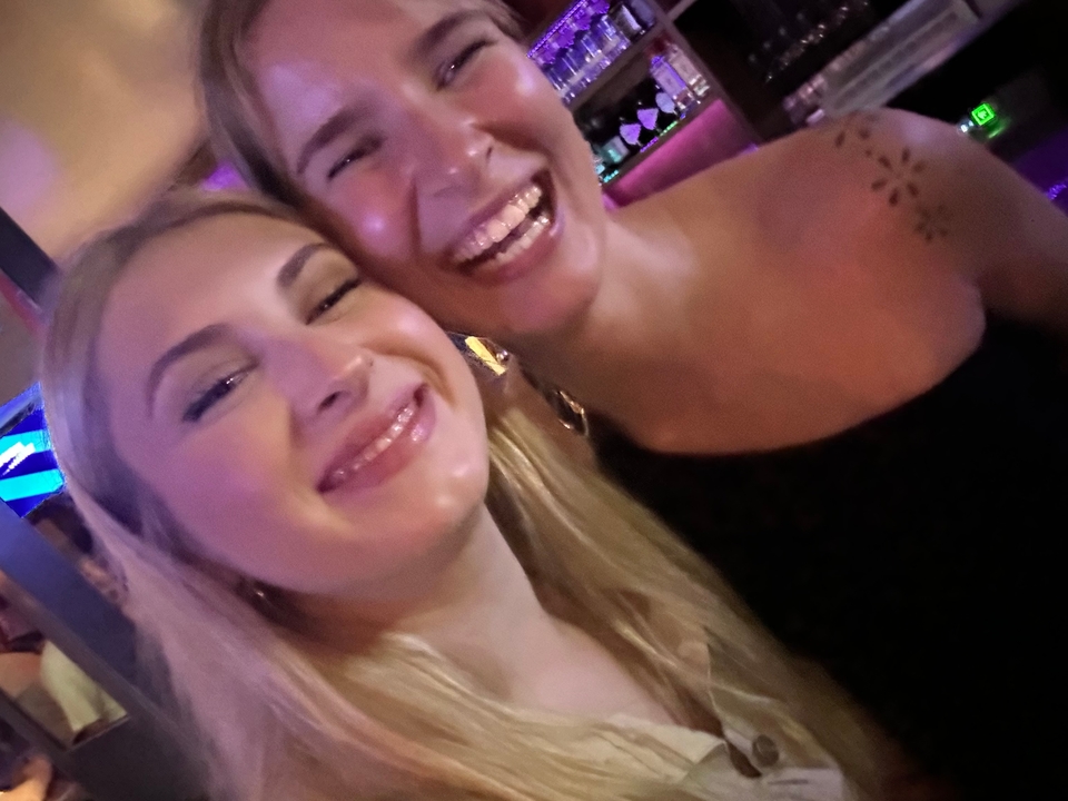 Two women enjoying a night out at a lively venue.