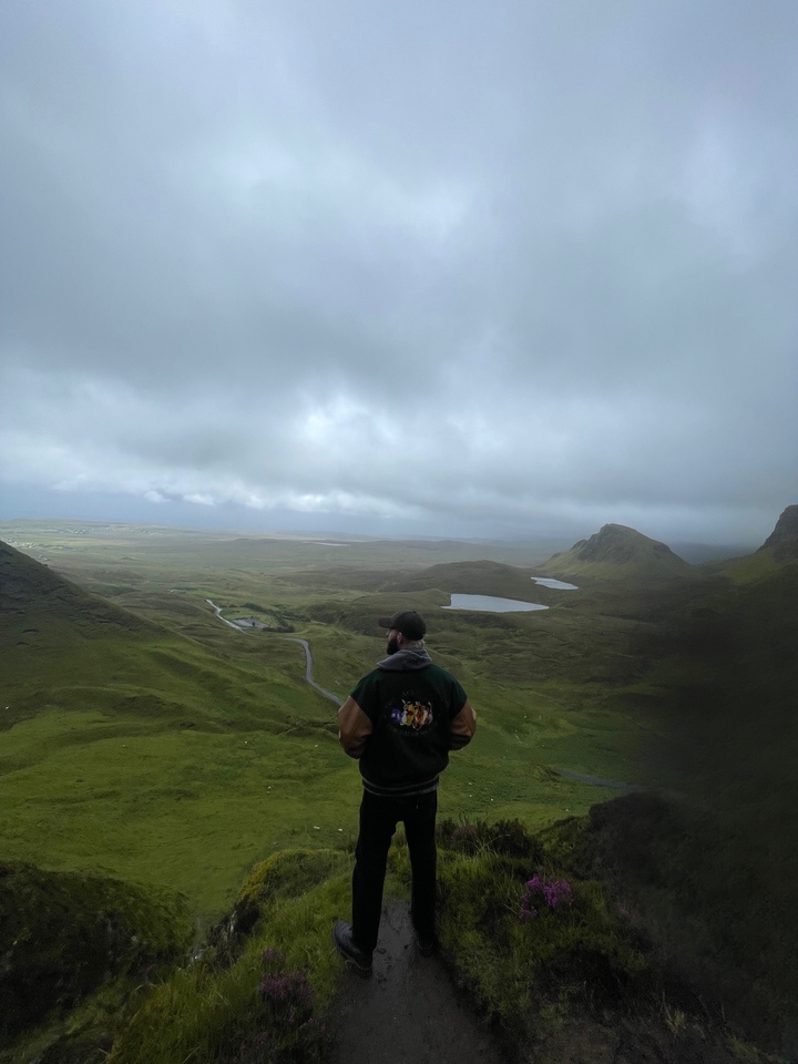 Person viewing scenic landscape of valleys and lakes.