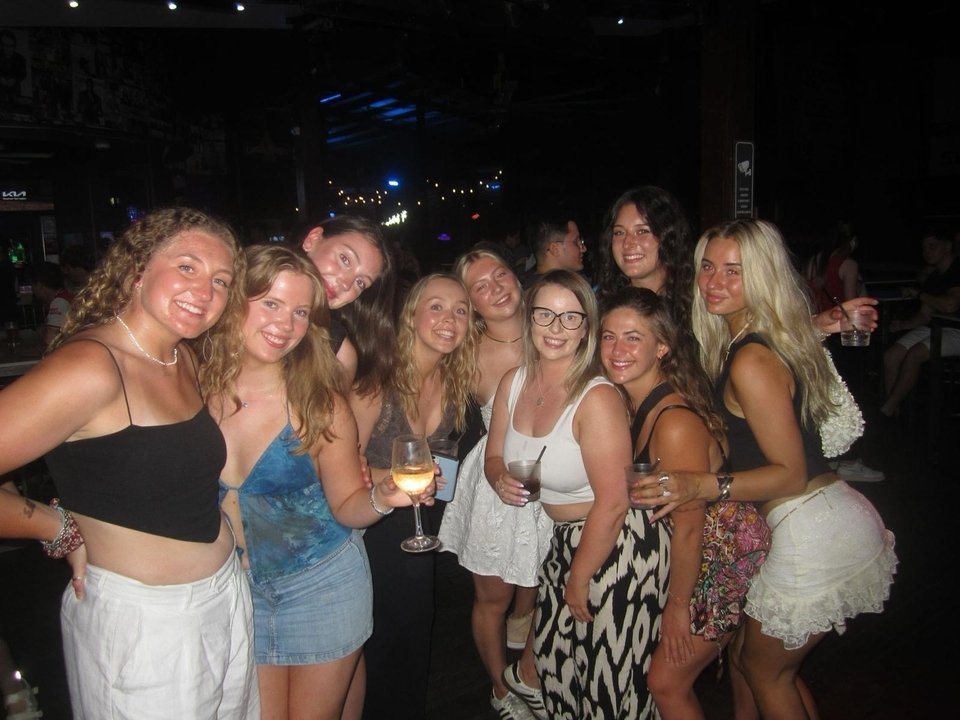 Group of women enjoying drinks at night.