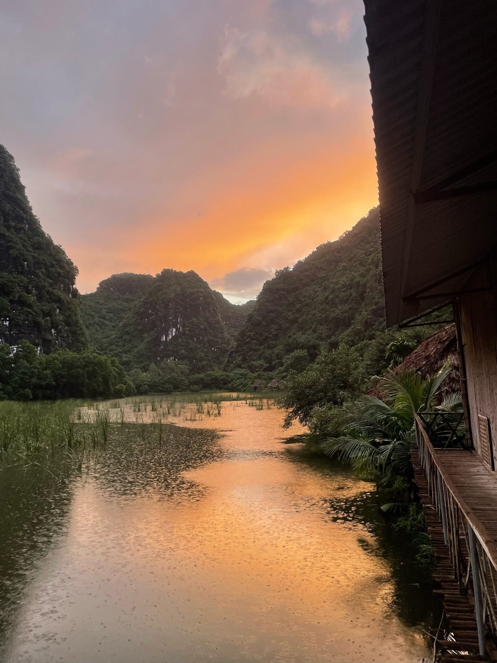 Sunset over a mountainous landscape with a serene lake.