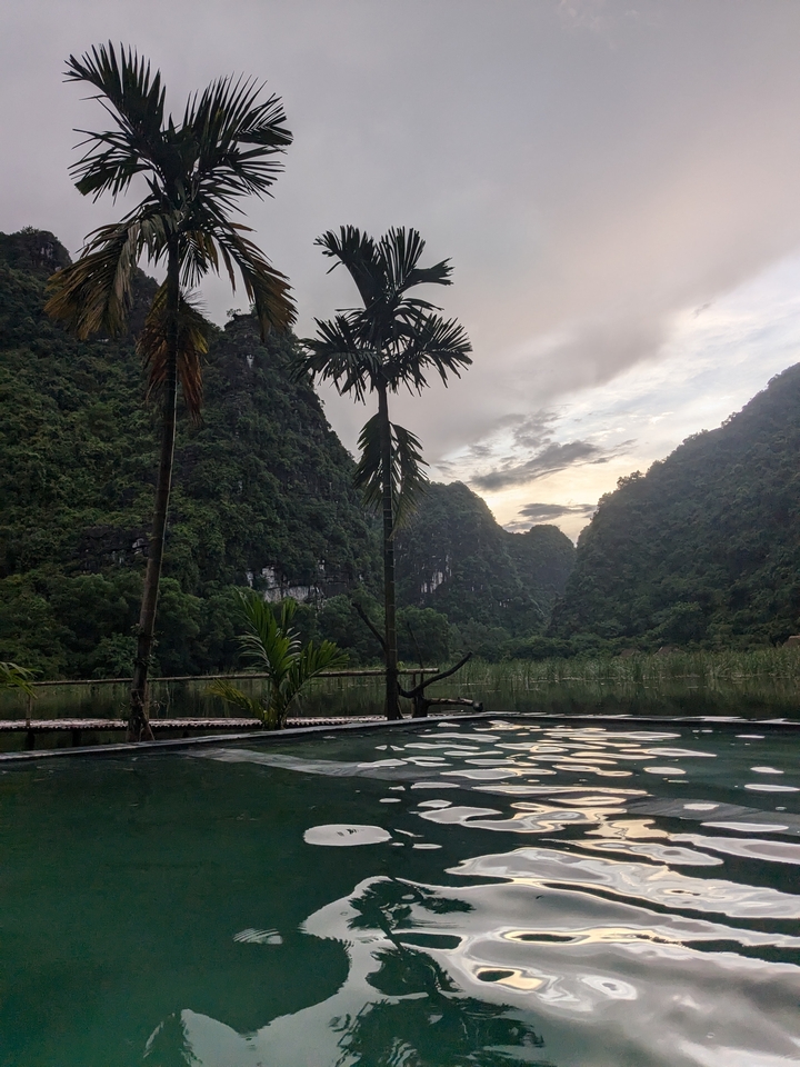 Mountainous landscape with a small pond at dusk.