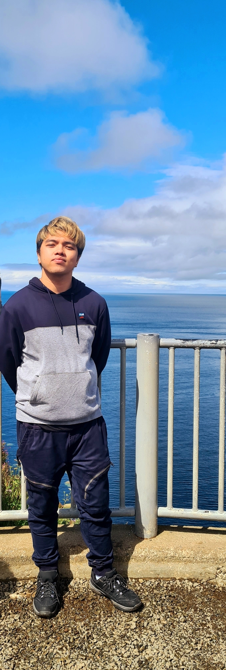 Partial view of a person next to a body of water.