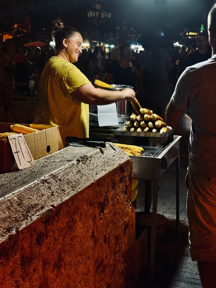 Vendeur de nourriture de rue grillant du maïs la nuit.