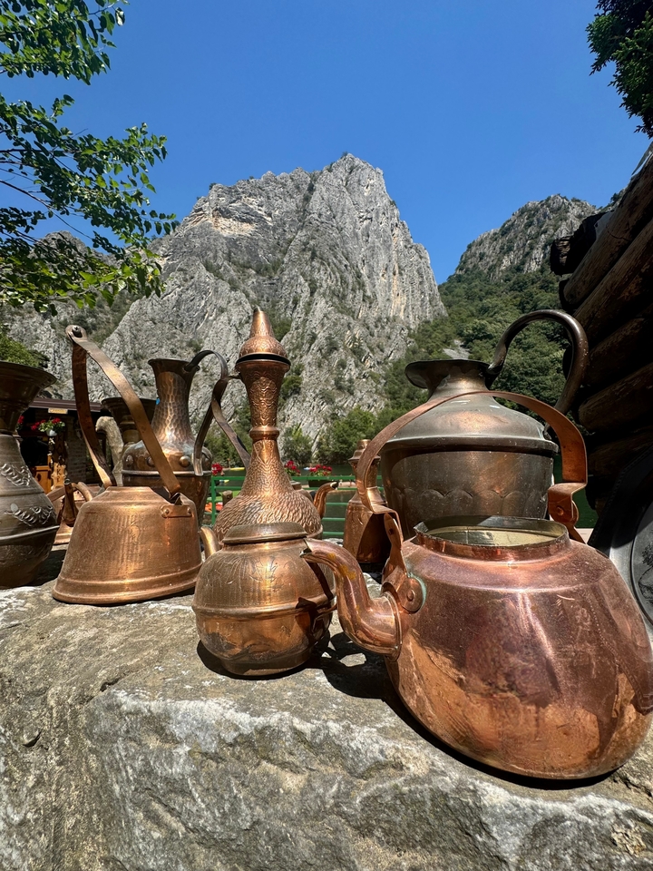 Ustensiles et récipients artisanaux en cuivre avec montagnes.