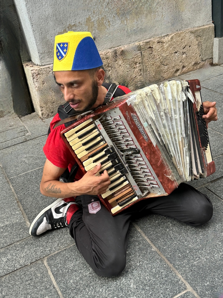 Homme jouant d'un accordéon usé dans la rue.