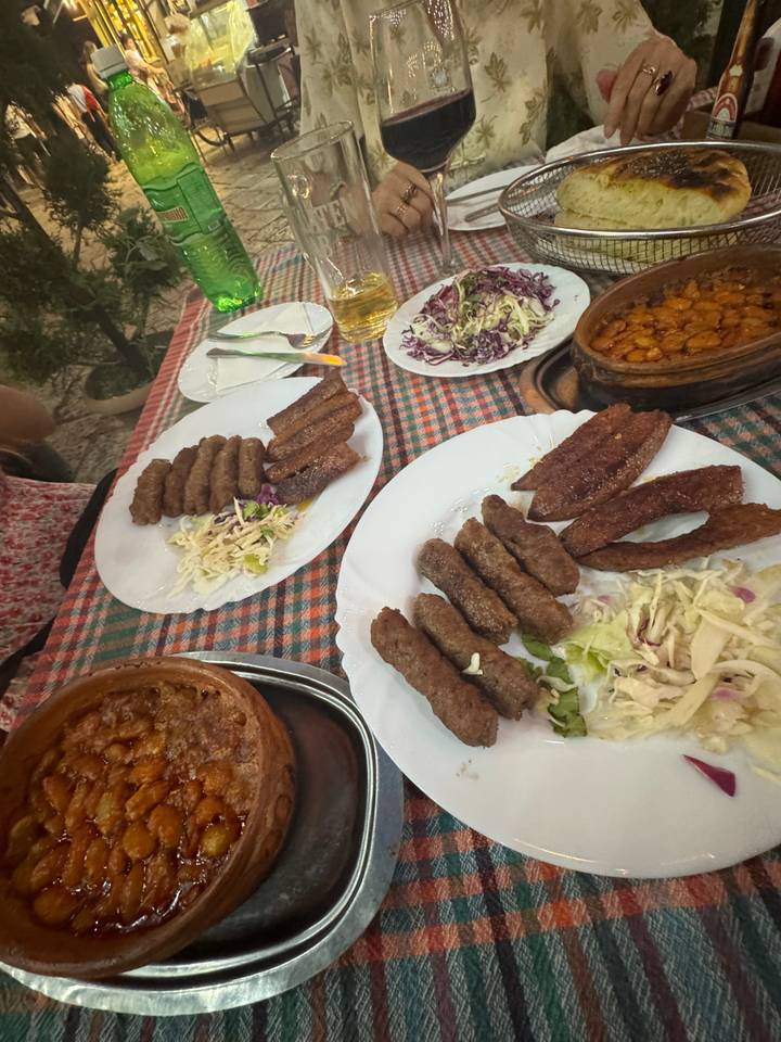 Plusieurs assiettes de plats de viande sur une nappe à carreaux.