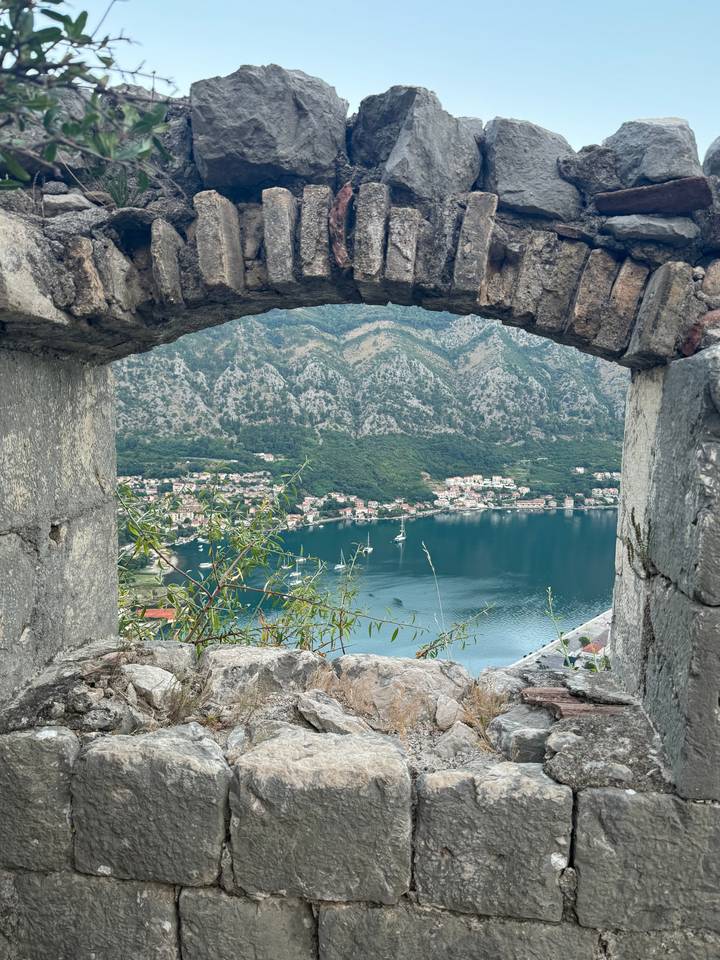 Vue d'une baie à travers une arche de pierre ancienne.