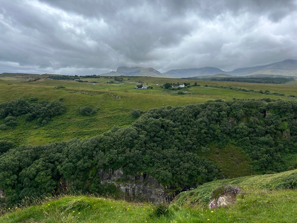 Rolling hills with a distant view of scattered houses.