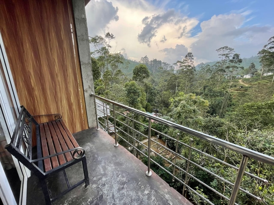 Vue du balcon sur une forêt luxuriante et des collines verdoyantes.