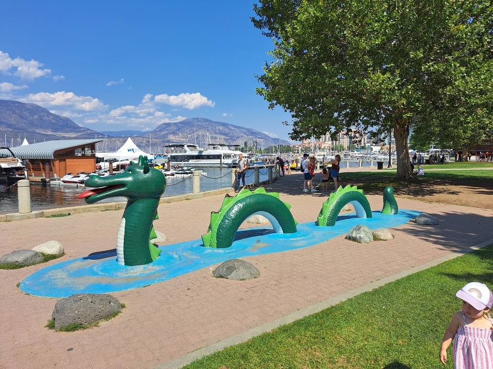 Play area featuring a dragon on a lakeside path.