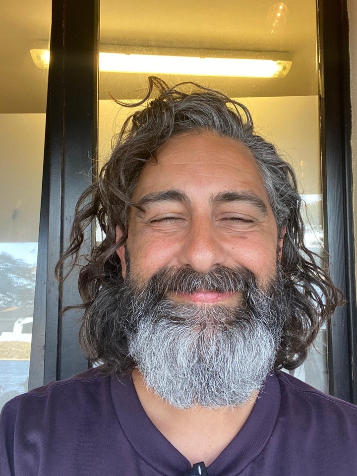 Close-up of a smiling man with a beard.