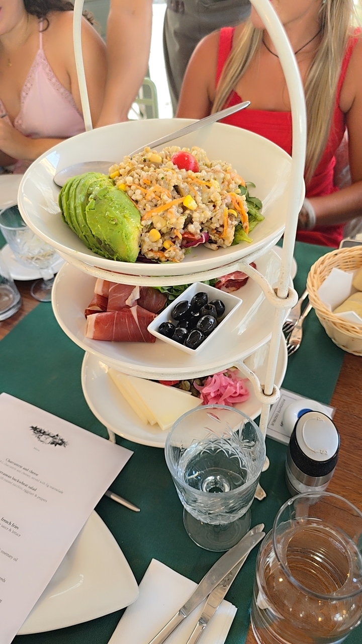 Three-tiered dish of appetizers and snacks.