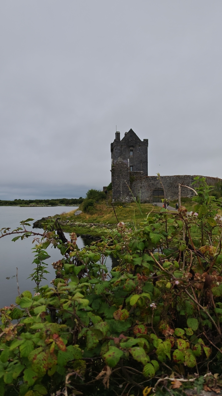 A historic stone tower by a lake.