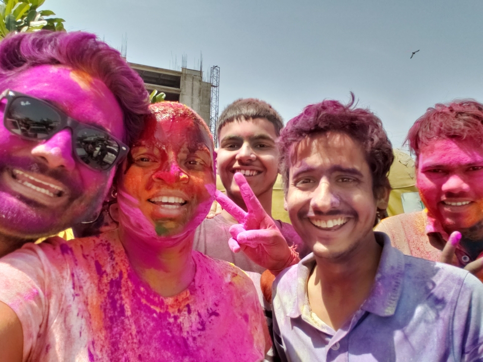 Groupe de personnes célébrant Holi, couvertes de poudre colorée.