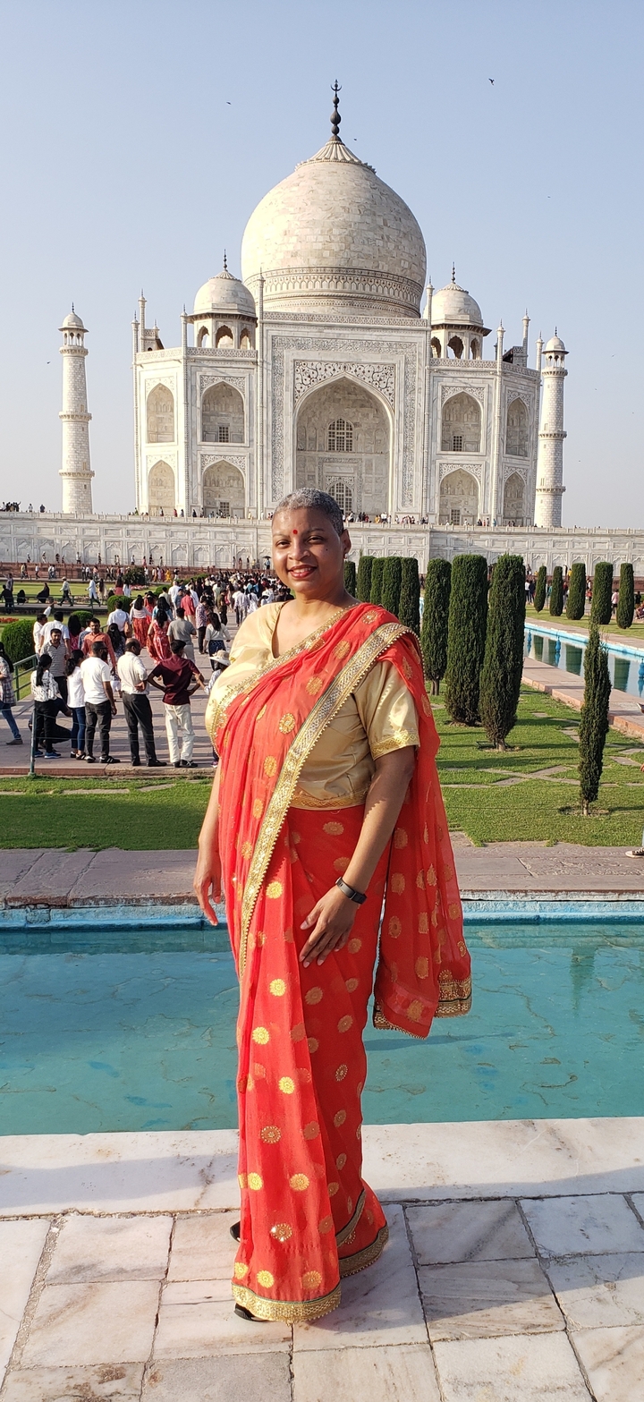 Femme en tenue traditionnelle posant au Taj Mahal.