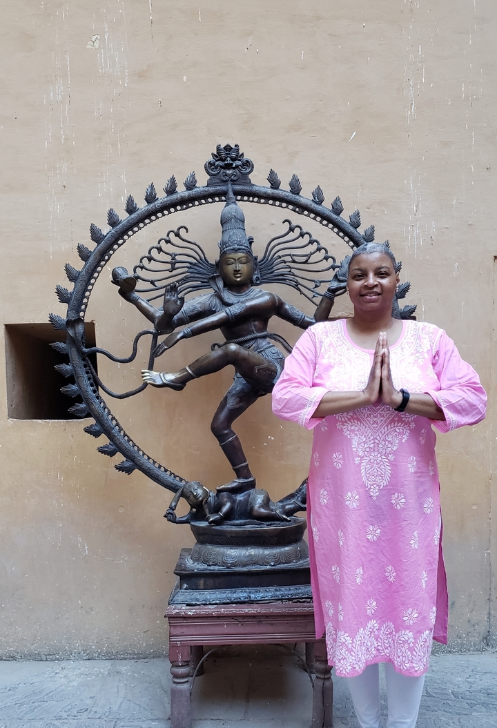 Femme posant avec une statue de Nataraja.