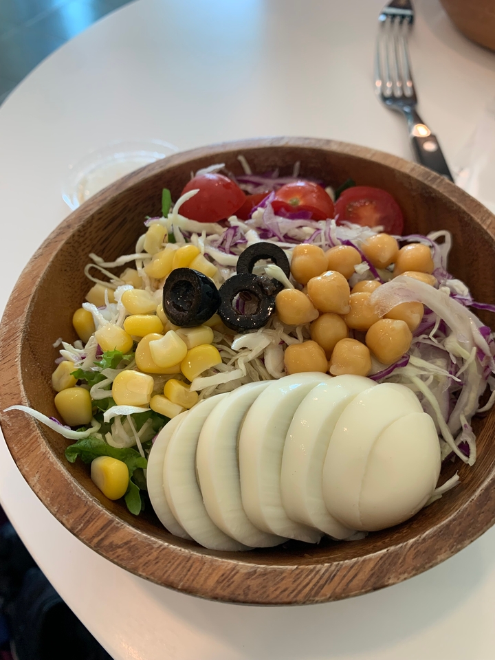 Gros plan d'une salade avec divers légumes et des œufs.