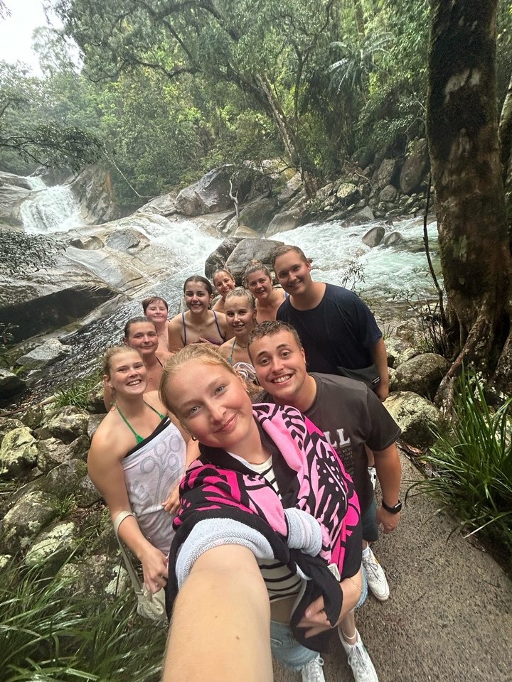 People posing near a waterfall.