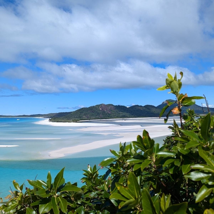 View of a beach with white sand and blue waters.