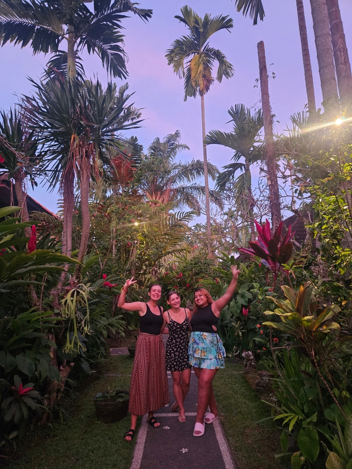 Three people posing among lush tropical plants
