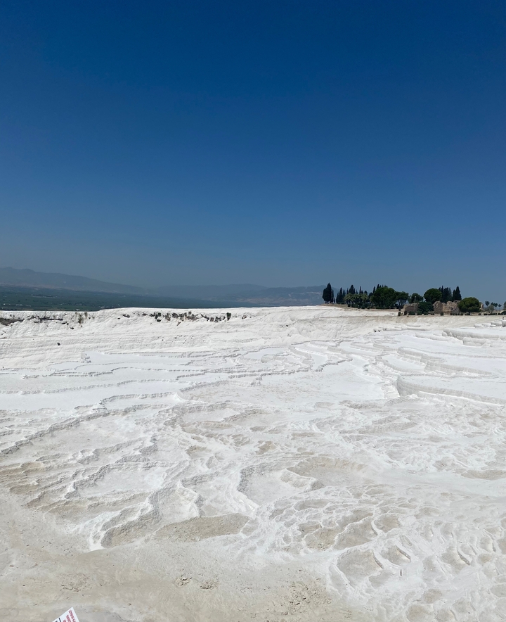 Terrasses de calcaire blanc avec un ciel dégagé.