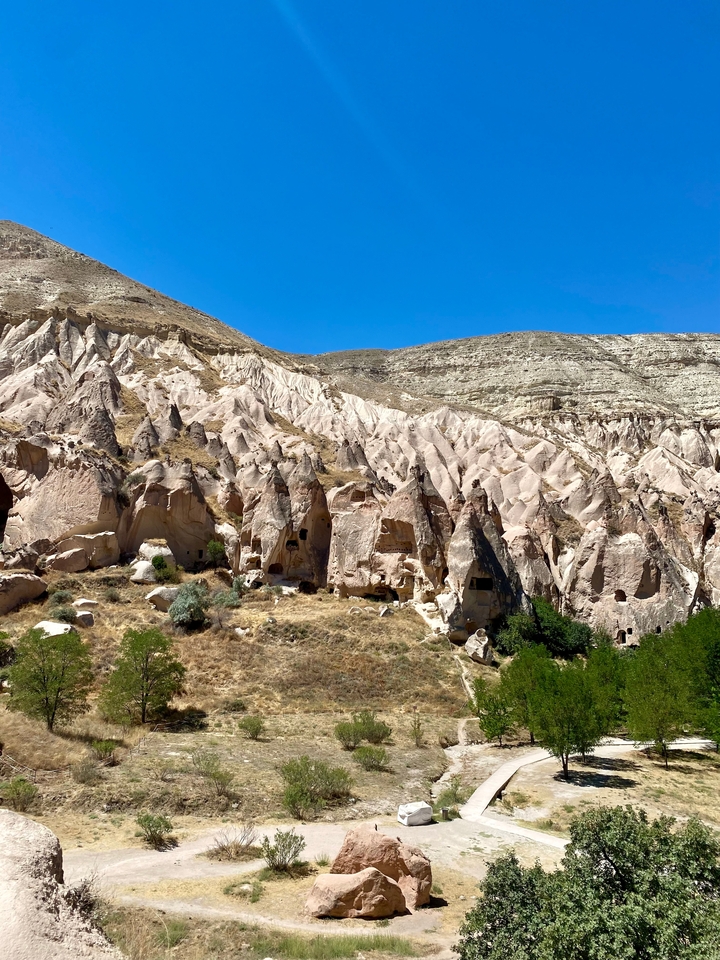 Formations rocheuses et grottes avec un ciel bleu clair.