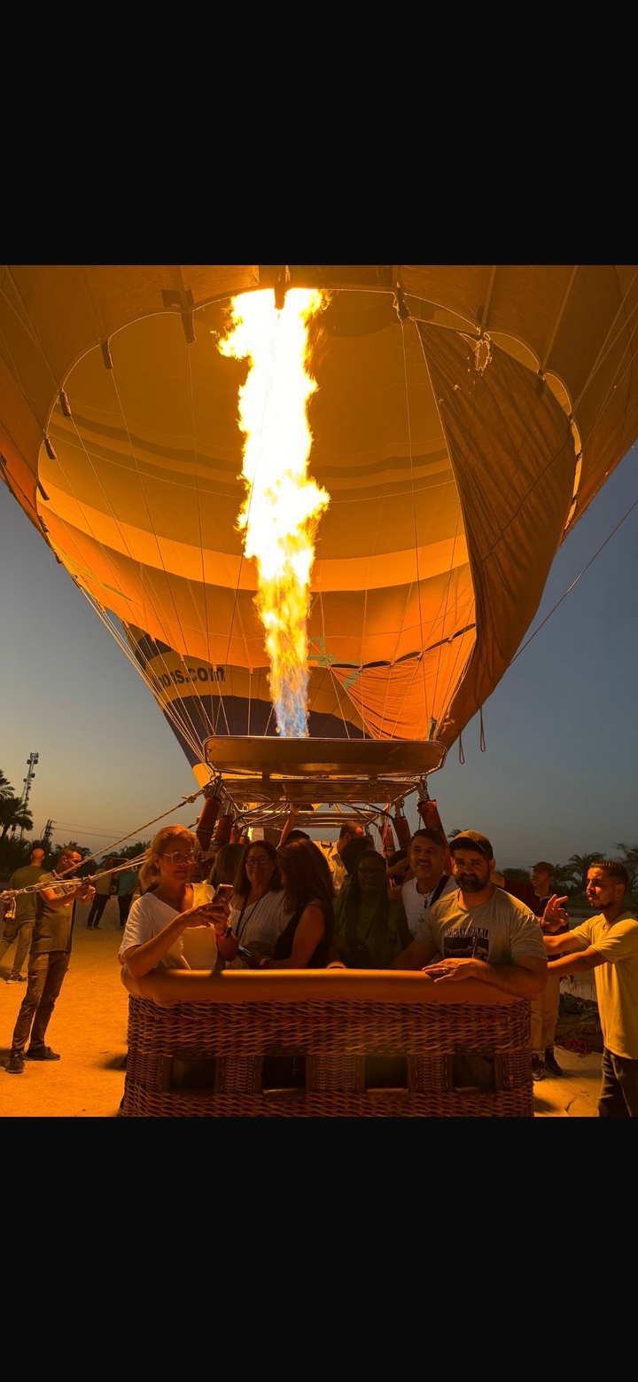 Des personnes se préparant à décoller dans une montgolfière avec la flamme visible.