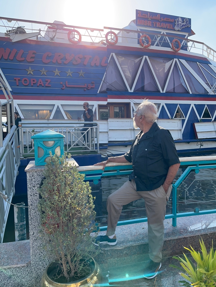 Une personne sur un bateau de croisière regardant un autre navire à proximité.