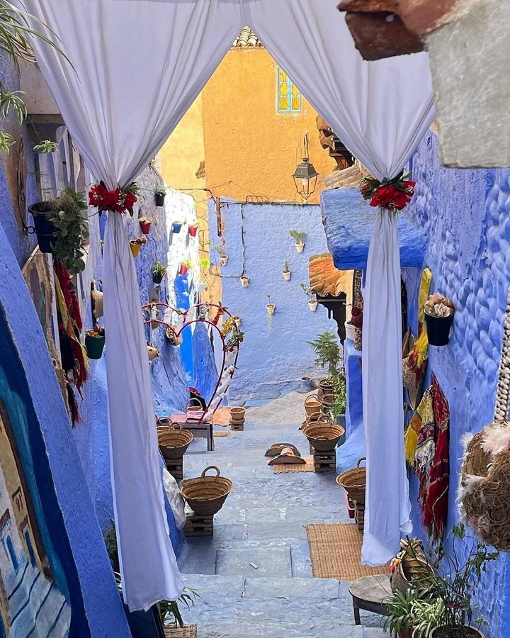 Ruelle bleue décorée avec des plantes et une décoration en forme de cœur.