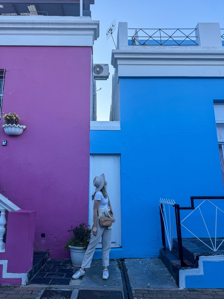 Person looking up at a building with colorful walls.