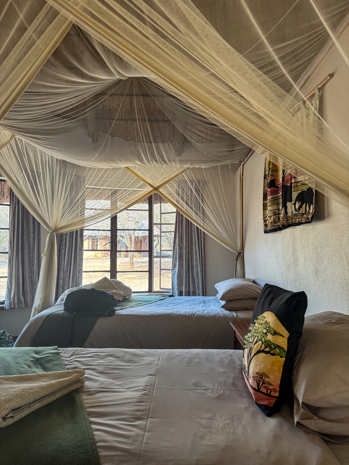 Interior of a bedroom with a bed and mosquito net.