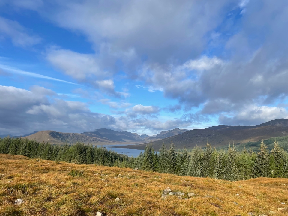Scenic view of mountains and a lake with cloudy skies.