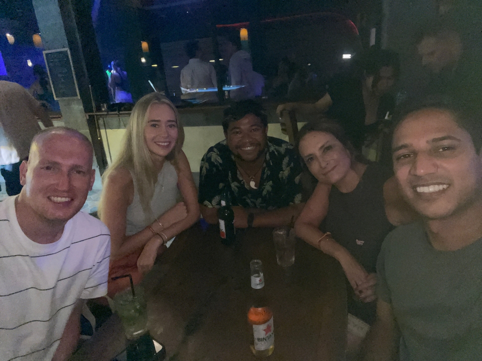 Friends at a dimly lit bar or club at night.