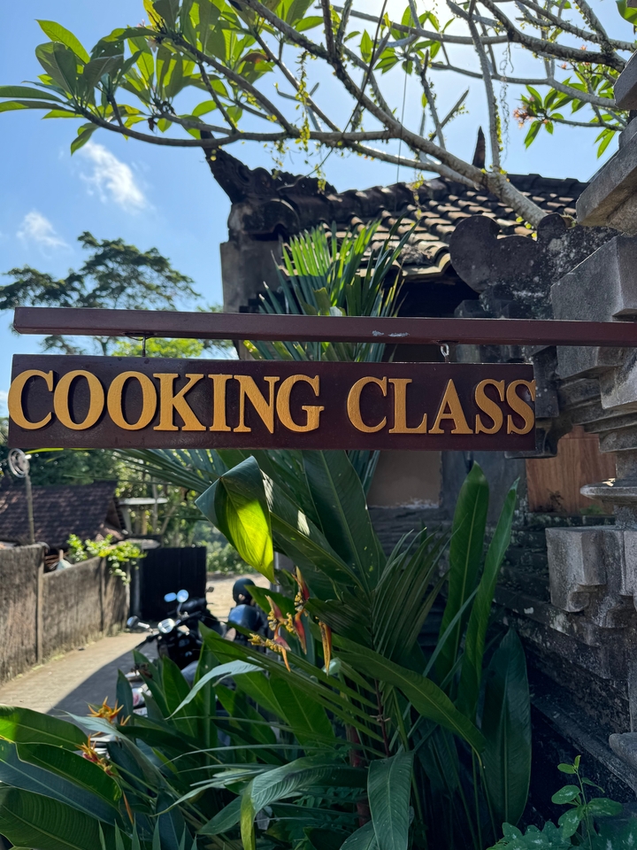 Sign that reads 'Cooking Class' surrounded by greenery.