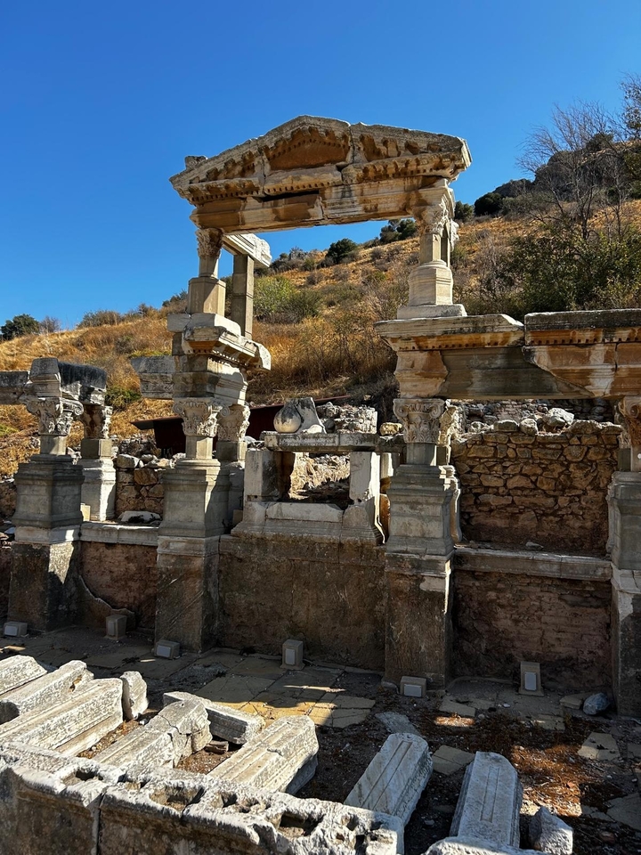 Ruines anciennes avec des colonnes de pierre et un relief sculpté.